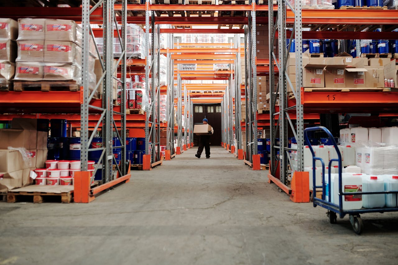 Mastering the First Impression: Your intriguing post title goes here A worker carrying a box in a well-organized warehouse storage aisle.